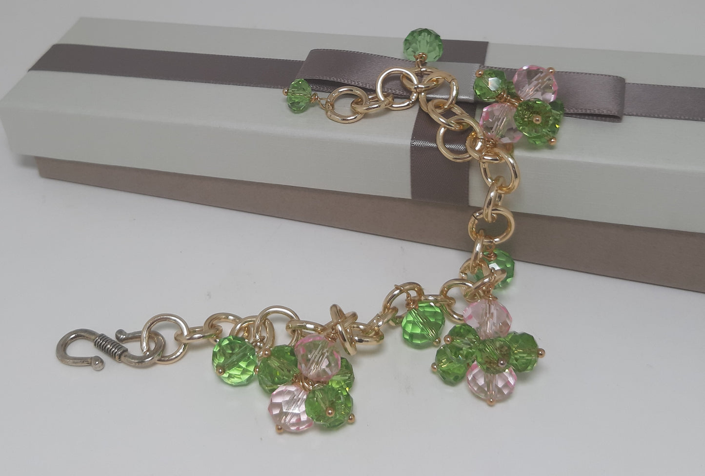 Bracciale I CRISTALLI .077 metallo dorato ciondolini cristallo verde e rosa.