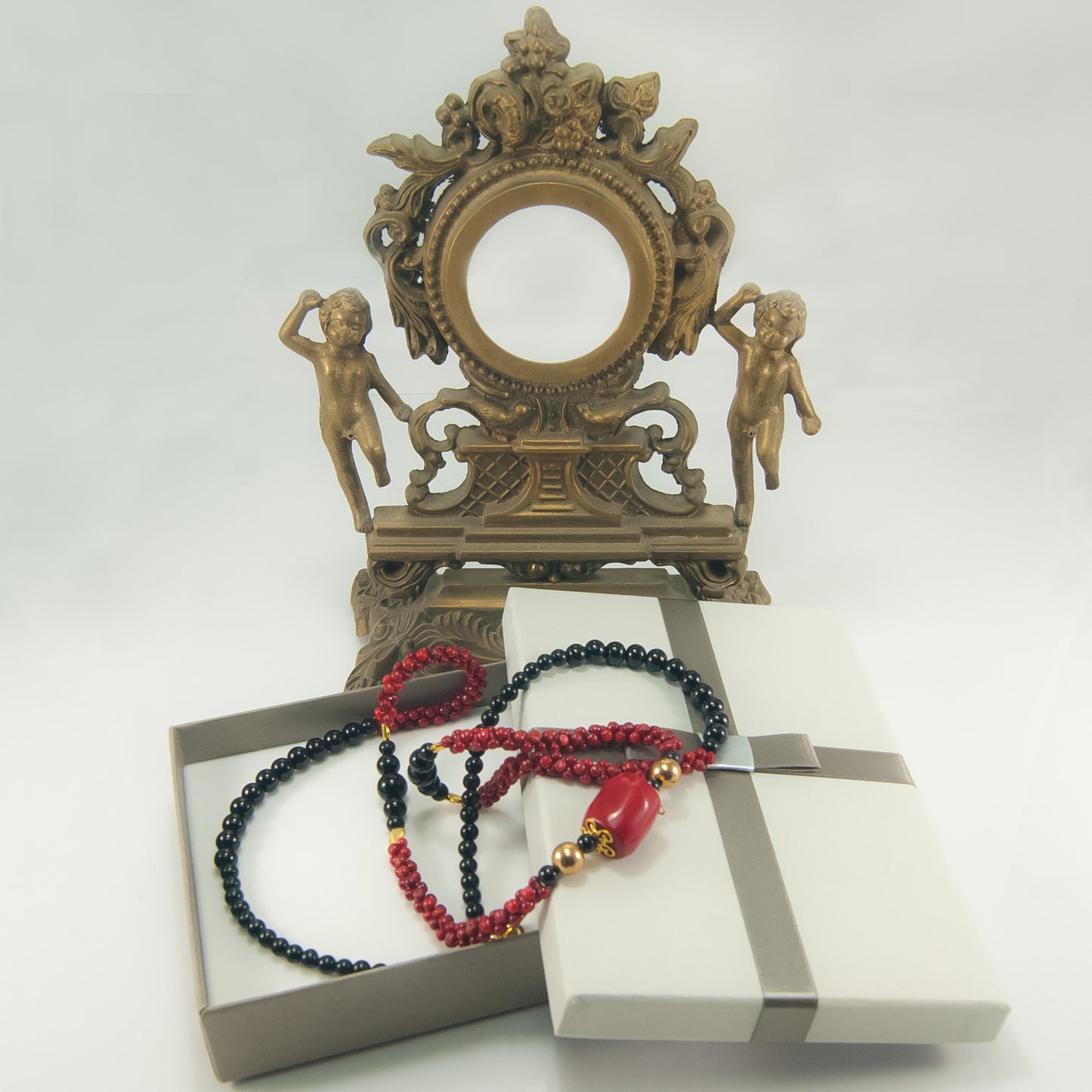 Collana I ROSSI .010, lungo filo perle onice varie misure, intrecci e centrale corallo, elementi dorati.