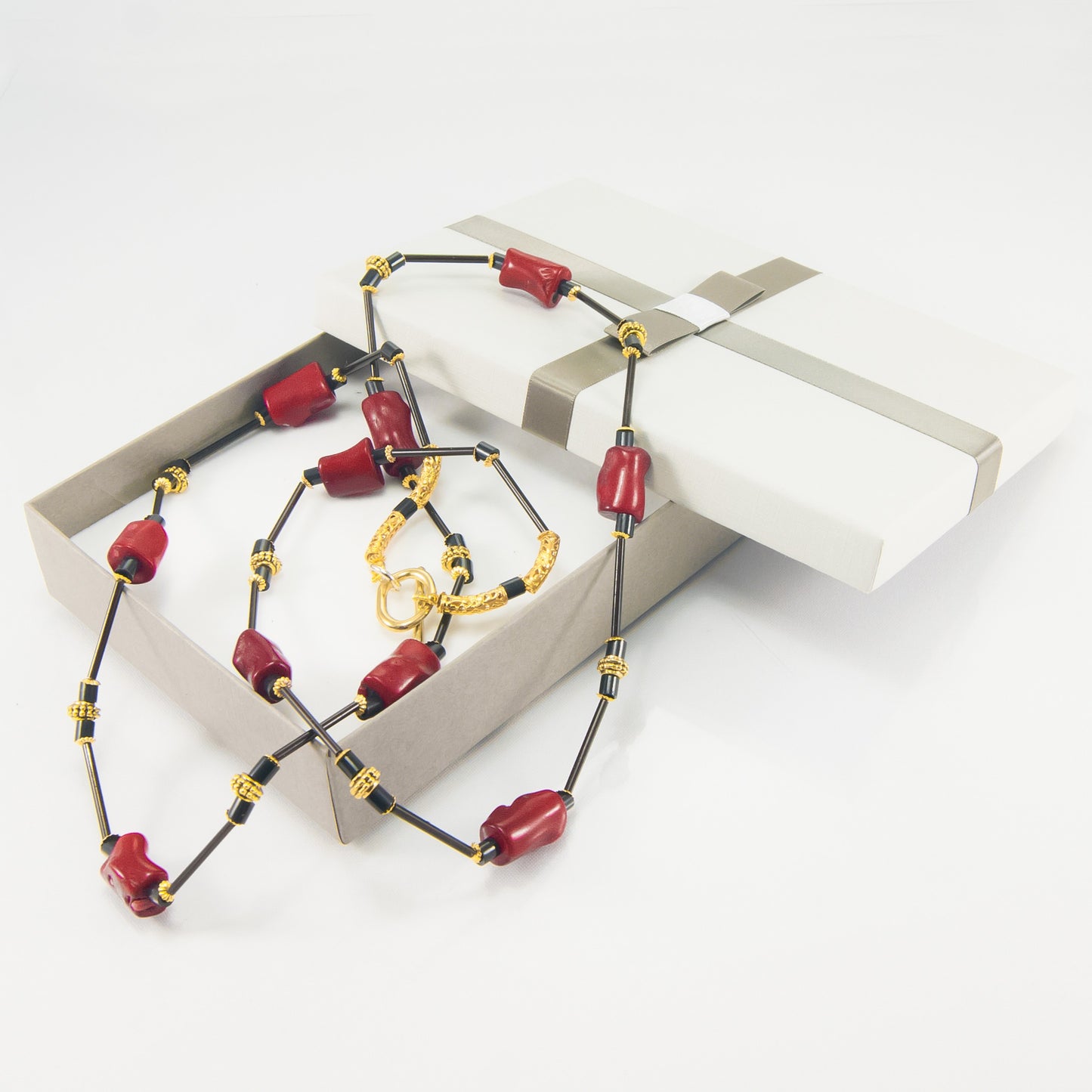 Collana I ROSSI .015, bauletti irregolari corallo rosso, elementi bakelite e metallo dorato.