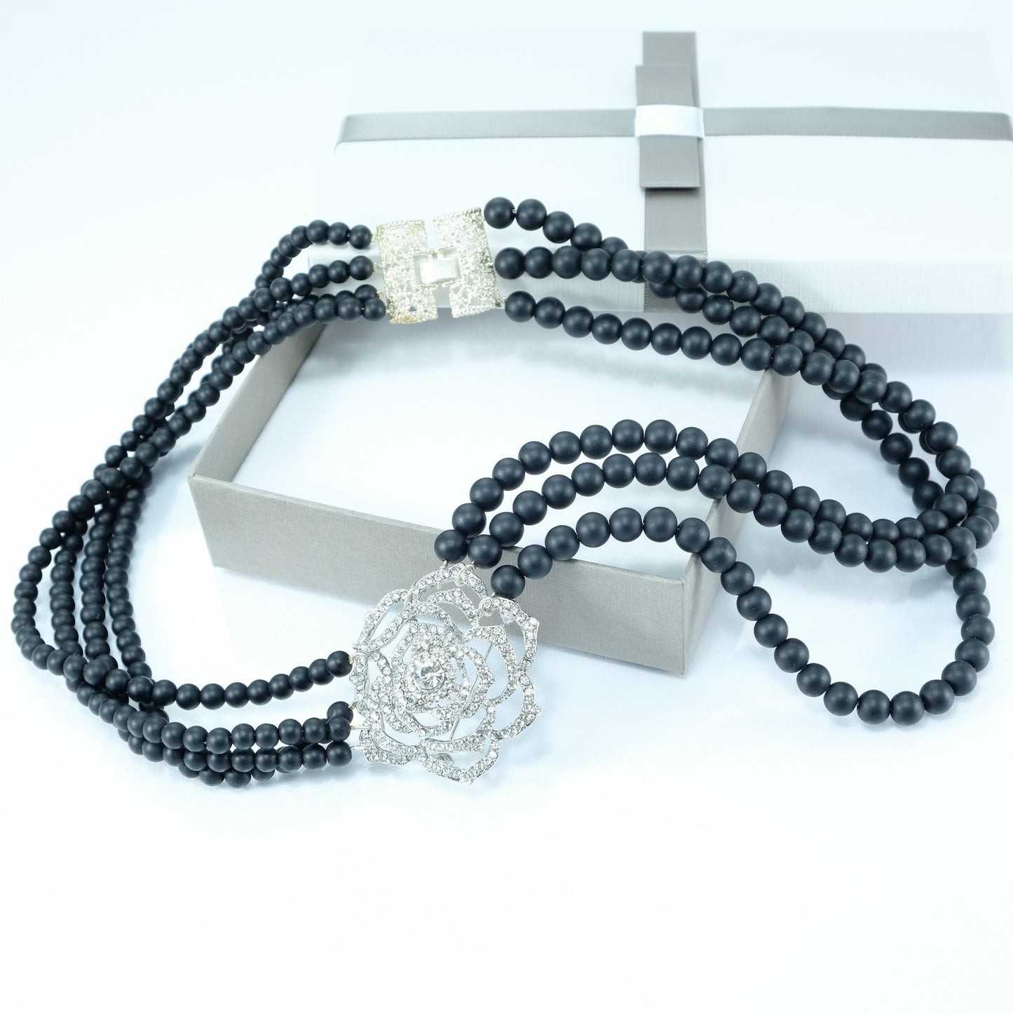 Collana LE PERLE .015 perle nere opache swarovski, rosa centrale in metallo e strass.