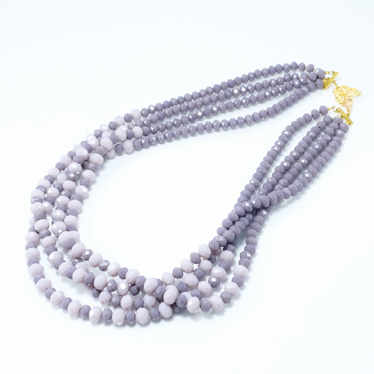 Collana I CRISTALLI .064, quattro fili di cristalli colore viola e lavanda. chiusura a farfalla traforata filigrana