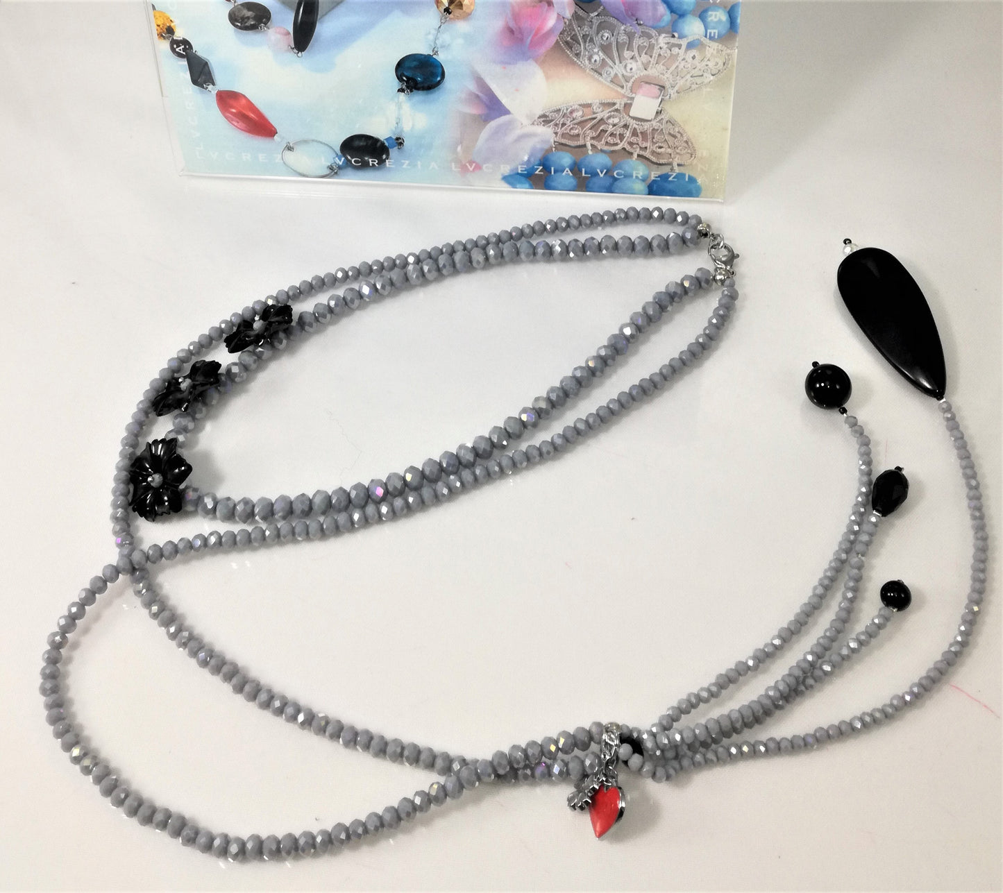 Collana I CRISTALLI .078 cristalli grigio lucidi con fiori neri, ciondolo con fuso e perle.