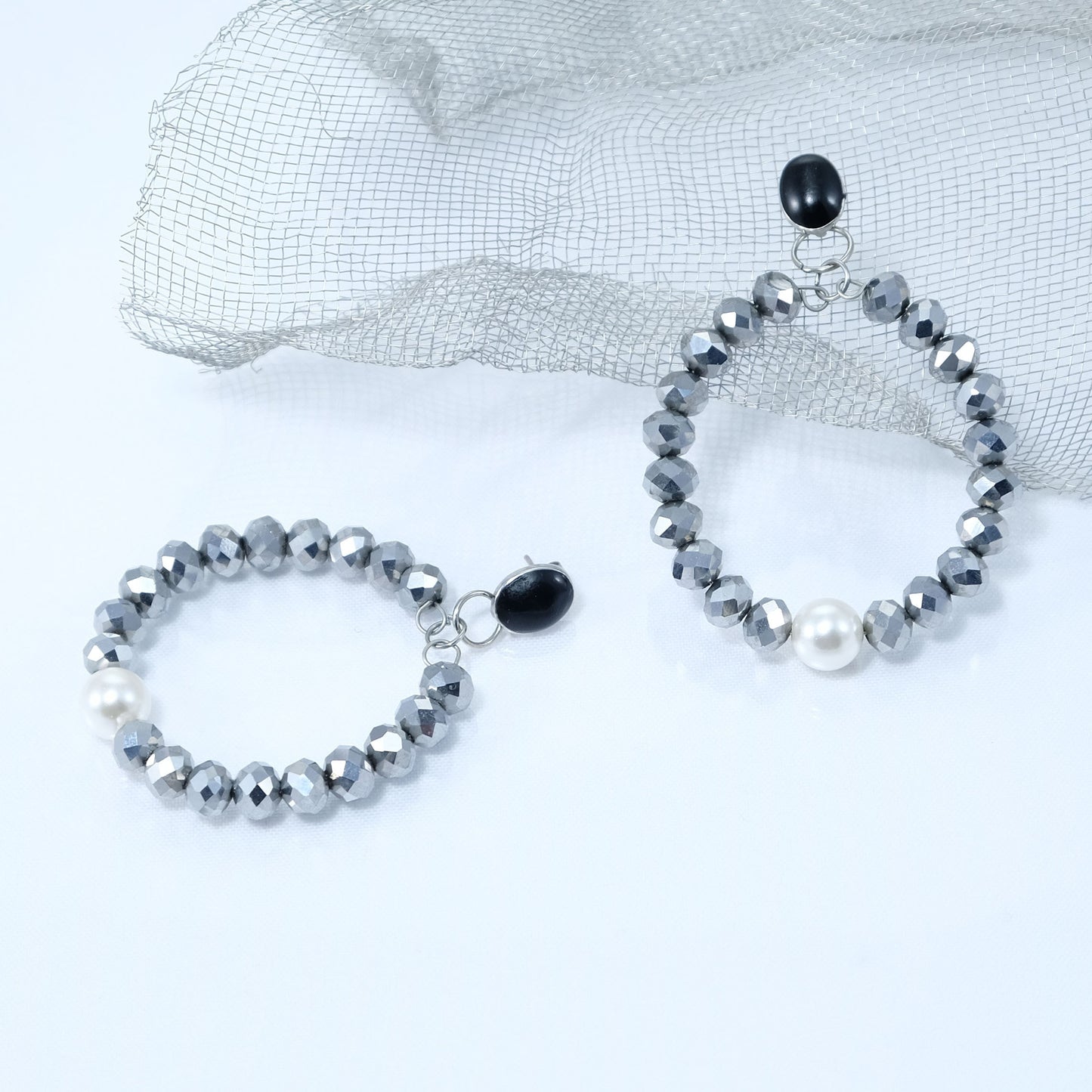 Orecchini I CRISTALLI .033 cerchio di mezzi cristalli colore argento monachella smalto nero e perla centrale.