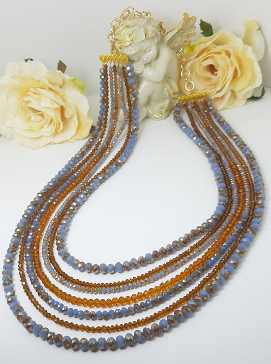 Collana I CRISTALLI .074  7 fili cristalli azzurro melange, brown con separatori finali metallo dorato.