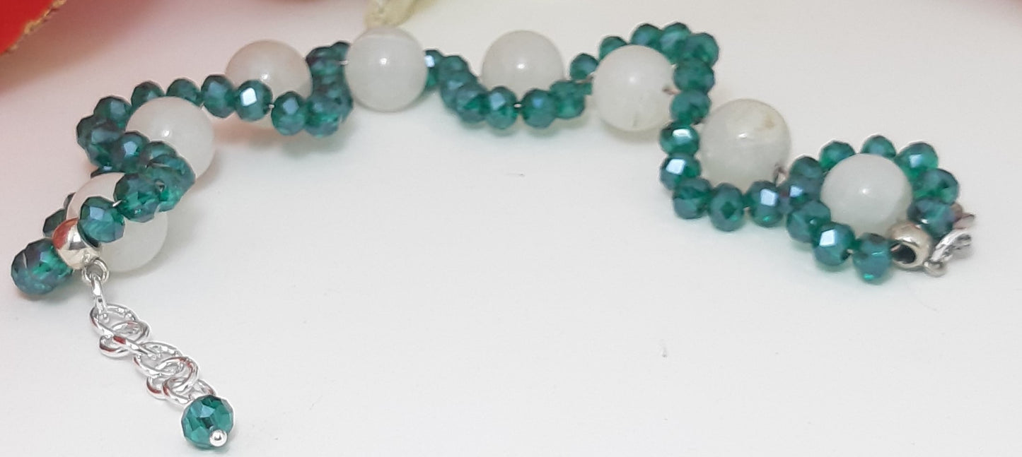 Bracciale ZELDA 038 di cristalli verde smeraldo legati da un filo di perle a spirale.