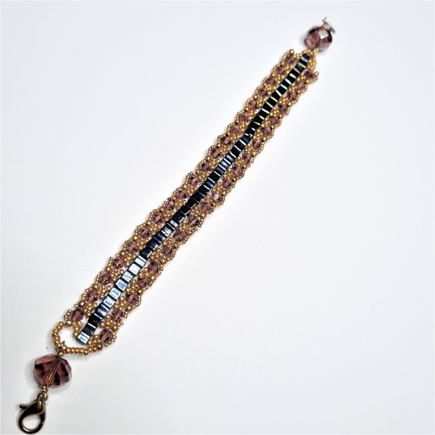 Bracciale ZELDA .027 quadrotti neri centrali, laterali cristalli color cipolla e oro.