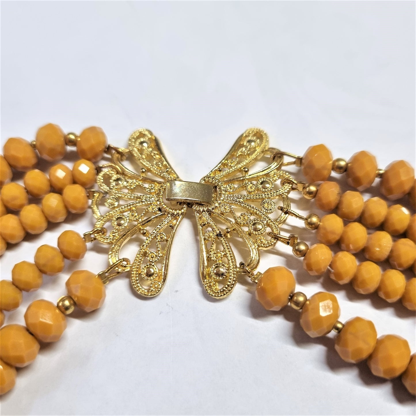 Collana I CRISTALLI .091 cinque fili di cristalli colore giallo intenso, chiusura a farfalla filigranata dorata.
