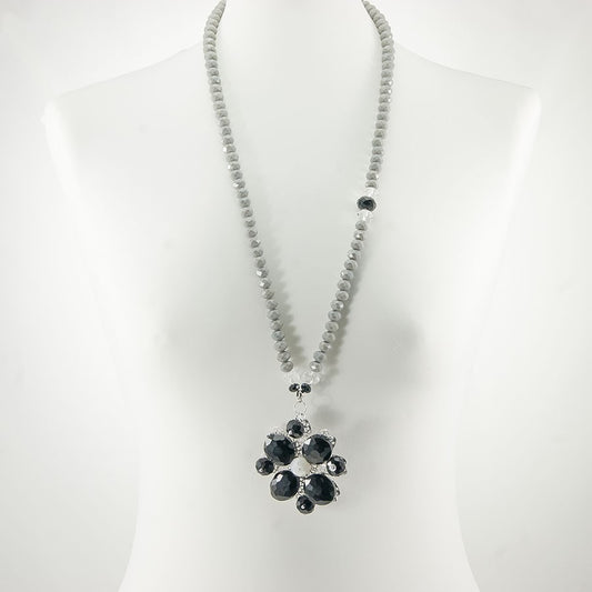 Collana I CRISTALLI .032,  cristalli grigi, grande ciondolo, cristalli neri formano un fiore con cuore bianco.