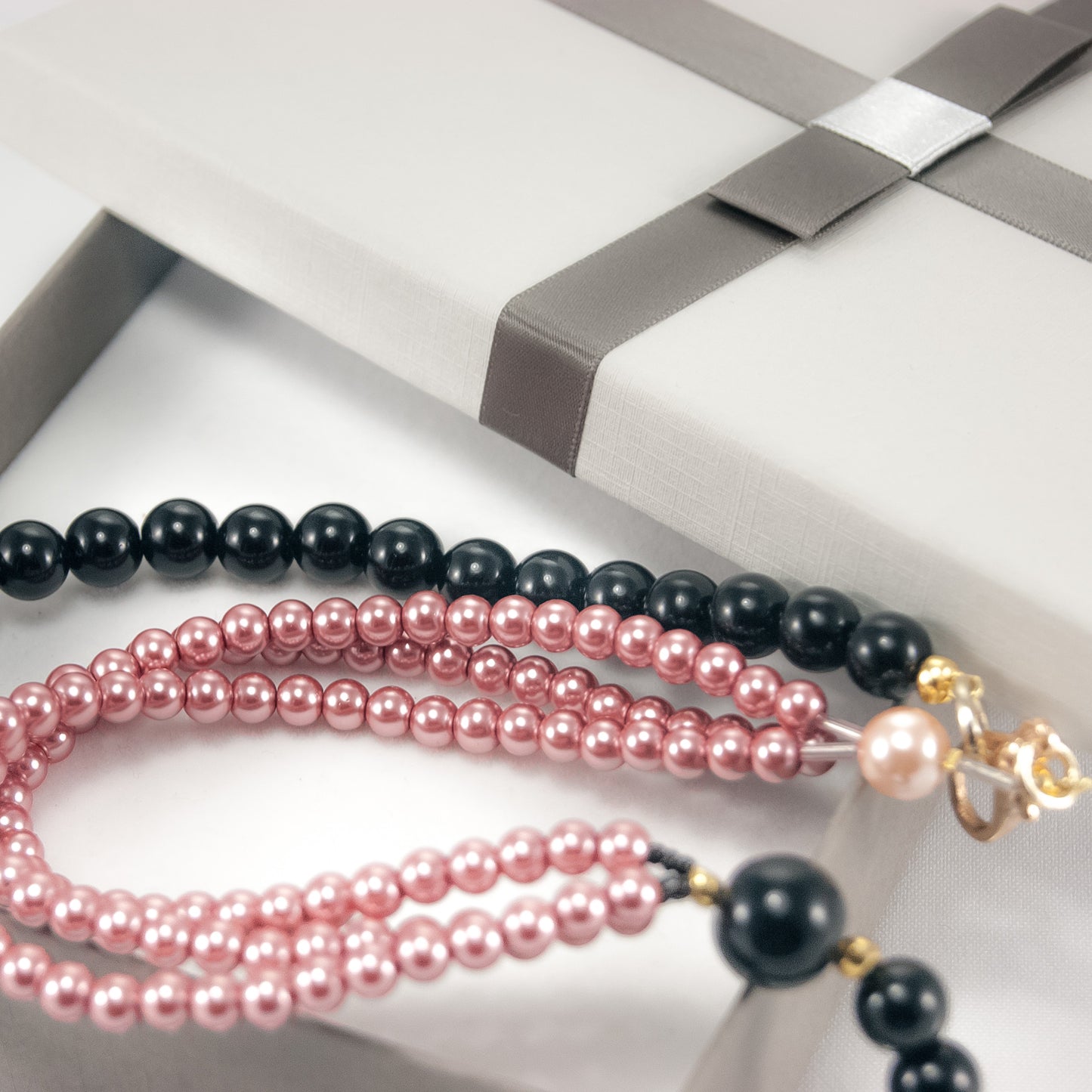 Collana LE PERLE .026, un filo perle onice legate a tre fili piccole perle rosa.