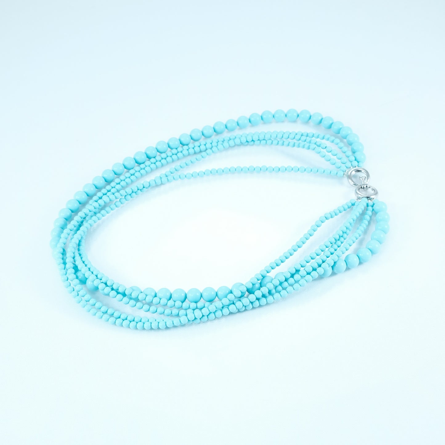Collana LE PIETRE .041  quattro fili di perline  pasta turchese accerchiate da un filo di perle più grande.
