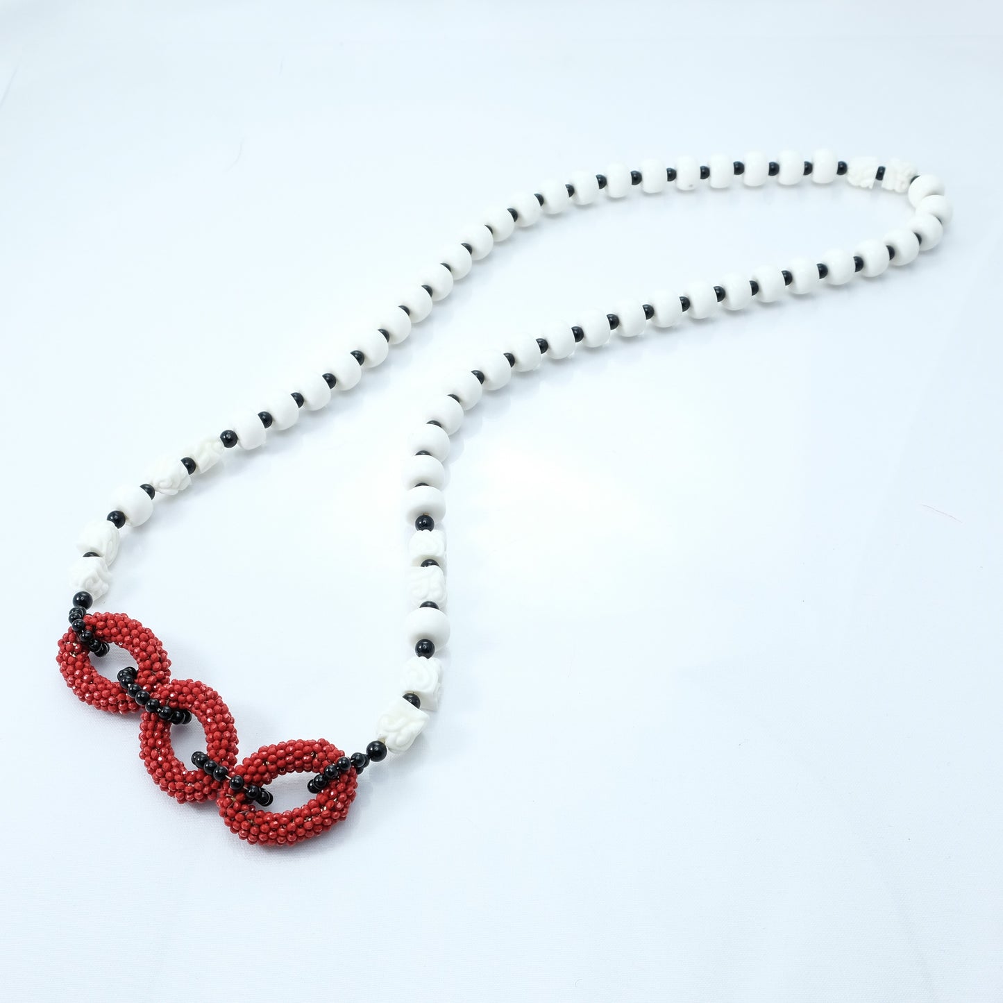 Collana SOPHIA i colori .017 lungo filo perle sintetiche bianche lisce e incise, onici e laterale rosso.